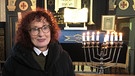 Anna Zisler vor dem Chanukka-Leuchter in der Straubinger Synagoge. | Bild: BR/Evelyn Schels