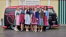 Die Landfrauen in Dirndl vor STOI-Shop und VW Bus. | Bild: BR/megaherz gmbh/Philipp Thurmaier