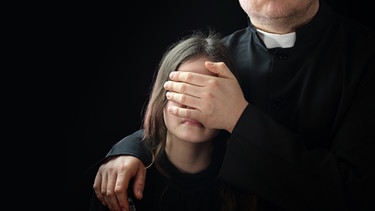 Ein Priester verdeckt einem Kind mit der Hand die Augen. | Bild: ARTE/BR/ECO Media TV-Produktion/Shutterstock.com/2021 ambrozinio