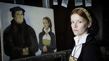 Katharina von Bora (Karoline Schuch) sitzt Lucas Cranach Modell für ein Doppelportrait mit Luther. | Bild: BR/EIKON Süd GmbH/MDR/Steffen Junghans