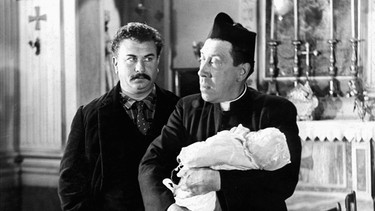 Don Camillo (Fernandel, rechts) weigert sich, das Baby seines Lieblingsfeindes Peppone (Gino Cervi) zu taufen. | Bild: ARD Degeto