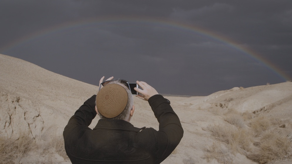 Gabriel Strenger entdeckt an seinem Lieblingsmeditationsplatz in der Wüste zufällig einen Regenbogen. | Bild: BR/Sandra Gold productions/Carla Muresan