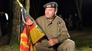 Bernd Lehmann in Uniform und mit Fahne. | Bild: BR