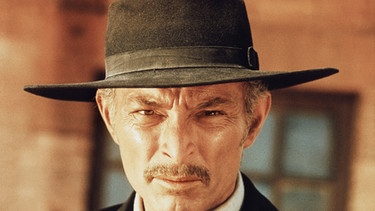 Colonel Douglas Mortimer (Lee Van Cleef) trägt die Kleidung eines Geistlichen, ist jedoch ein berüchtigter Kopfgeldjäger, der das Lösegeld für El Indio einstreichen möchte. | Bild: Arturo Gonzales Madrid/BR/Constantin-Film GmbH München/P.E.A. Rom/Tobisfilm