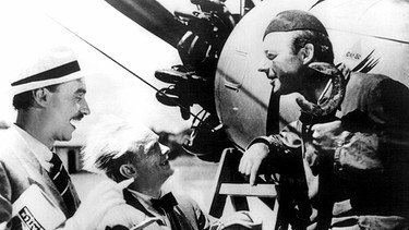 Flugschüler Otto Groschenbügel (Heinz Rühmann, rechts), genannt "Quax", gibt mächtig an, als ihn zwei Journalisten interviewen. | Bild: © ARD Degeto, honorarfrei 