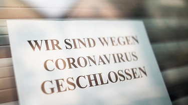Schild in einem Ladenfenster auf dem steht "Wir sind wegen Coronavirus geschlossen" | Bild: picture-alliance/dpa/Christoph Schmidt