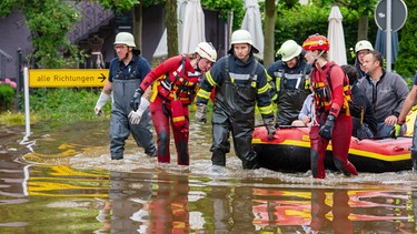 Mit einem Schlauchboot holen Feuerwehr und Wasserretter Anwohner aus ihren überfluteten Häusern in Wertingen. | Bild: picture alliance/dpa | Stefan Puchner