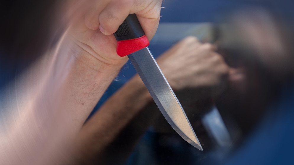 Symbolbild Messerattacke: Nahaufnahme von einem Messer in der Hand eines Mannes | Bild: picture alliance / CHROMORANGE | Udo Herrmann