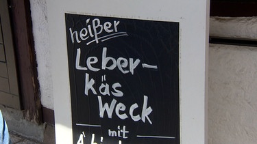 Tafel mit Aufschrift "heißer Leber-Käs Weck" | Bild: BR