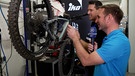 Martin Breitkopf prüft  mit einem Mechaniker ein Fahrrad | Bild: BR