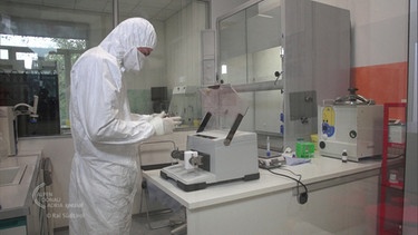 Ein Mann in Schutzkleid bei Laboruntersuchungen | Bild: BR