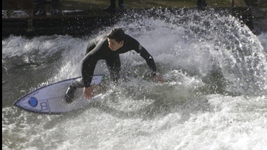 Ein Mann auf einem Surfbrett auf einer Welle | Bild: BR