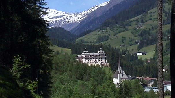 Ein Schloss in einem Tal vor bergigem Hintergrund | Bild: BR