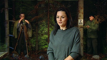 Nensi Puskaric in einem Szenario mit Figuren bei der Waldarbeit | Bild: BR