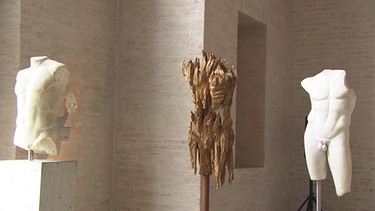 Holzskulptur zwischen zwei antiken Torsi | Bild: BR