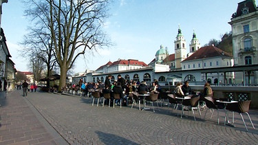 Ljubljana - Stühle und Tische am Flussufer | Bild: BR