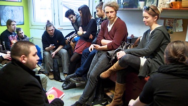 Junge Leute sitzen in einem Raum zusammen | Bild: BR