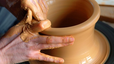 In der Keramik-Werkstatt wird an der Töpferscheibe eine Vase geformt | Bild: picture-alliance/dpa