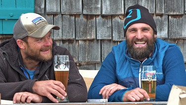 Christian Bauernfeind (l.) und Luis Badrexl sitzen beim Bier vor der Hütte | Bild: BR/Josef Bayer