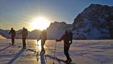 Eine Gruppe Skitourengeher im Gegenlicht | Bild: BR