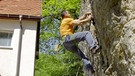 Kletterer in einer Wand direkt neben einem Wohnhaus | Bild: BR