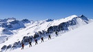 Skitourengruppe im Aufstieg bei strahlendem Sonnenschein | Bild: BR/Michael Düchs