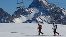 Zwei Skitourengeher beim Aufstieg unter stillgelegtem Sessellift | Bild: BR/Georg Bayerle