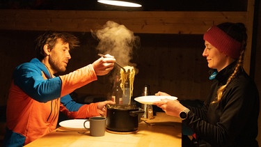 Bergsteiger am Hüttentisch schöpft Spaghetti aus Topf | Bild: BR/Thomas März
