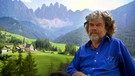 Reinhold Messner sitzt auf einer Bank; im Hintergrund hohe Berge. | Bild: BR