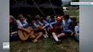 Pfadfinder sitzen in einer Gruppe, zwei spielen Gitarre | Bild: BR Archiv