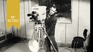 Ein Kameramann Fersehstudio mit Kopfhörer und in Anzug hinter der Kamera auf Rollen. | Bild: BR Archiv