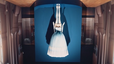 Bild einer auf dem Kopfstehenden Frau mit einem Kleid, welches ihr über den Kopf fällt. | Bild: BR