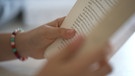 Zwei Hände lesen ein Buch | Bild: BR