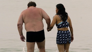 Weißer Mann steht mit Thai-Frau an der Hand im Meer von Pattaya | Bild: picture-alliance/ dpa/dpaweb | Boris Roessler