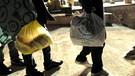 Symbolbild: Die Beine und Schatten von drei jungen Männern auf der Flucht, mit Plastiktüten in der Hand | Bild: picture-alliance/dpa