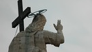 Vatikan in Rom: Jesusfigur mit Kreuz an der Fassadenspitze von hinten | Bild: BR / Eckhart Querner