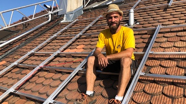 Projektleiter Pascal Tribolet macht eine Pause auf dem denkmalgeschützen Dach. | Bild: BR