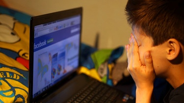 Ein Junge reibt sich in Leichlingen (Nordrhein-Westfalen) vor seinem Laptop beim betrachten der Facebook Seite die Augen. Eine umfangreiche Studie zum Thema Mobbing unter Kindern und Jugendlichen in Internet und sozialen Netzwerken wird in Köln vorgestellt. | Bild: picture-alliance/dpa