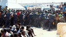 Beamte der Guardia di Finanza halten Flüchtlinge auf Lampedusa zurück. | Bild: BR