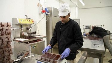 Ein Mann arbeitet mit Schokolade | Bild: BR