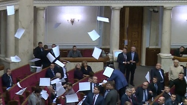 Papierblätter fallen im Parlament herunter. | Bild: BR