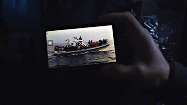 Foto eines Flüchtlingsboots auf einem Smartphone | Bild: BR