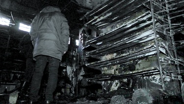Aziz im zerstörten Supermarkt | Bild: BR