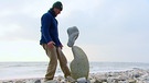 Ein Mann mit einer Steinfigur | Bild: BR