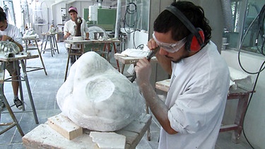 Ein Mann bearbeitet eine Skulptur an der Kunsthandwerkschule | Bild: BR