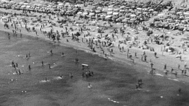 Ein Strand mit vielen Badegästen aus der Luft gesehen | Bild: BR