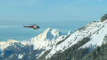 Ein Hubschrauber über den Bergen | Bild: BR