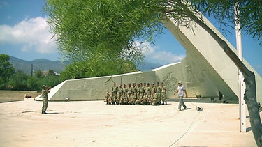 Soldaten lassen sich vor einem Denkmal fotografieren | Bild: BR