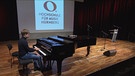 Israelischer Student sitzt auf einer Bühne am Klavier. | Bild: BR