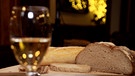 Brot und Wein auf einem Tisch. | Bild: BR